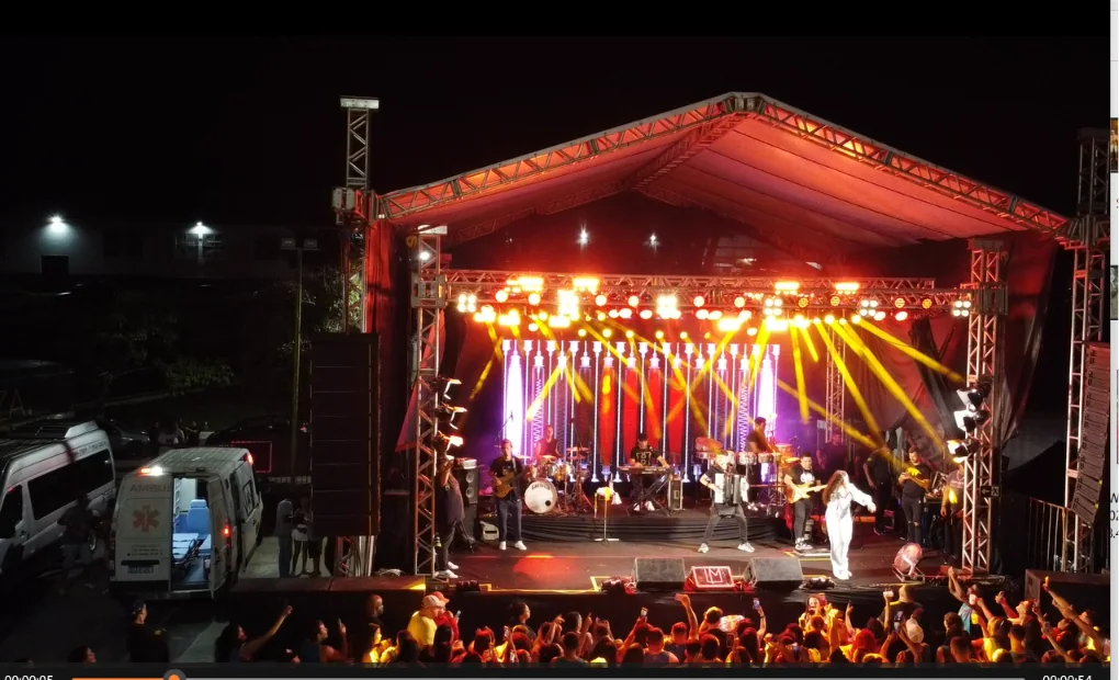 Palco coberto com iluminação cênica durante uma apresentação musical